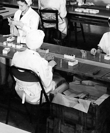 Worker adding lids to lipsticks